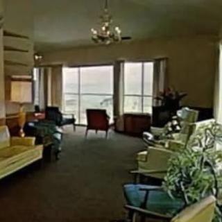 A spacious living room with a variety of seating options and large windows offering a view.