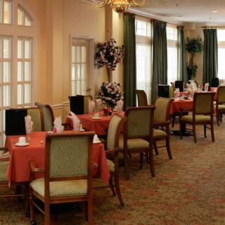 An elegant dining room with neatly arranged tables and chairs, featuring a warm and inviting ambiance.