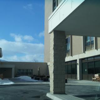 A modern building entrance with a stone column, set against a wintery backdrop.