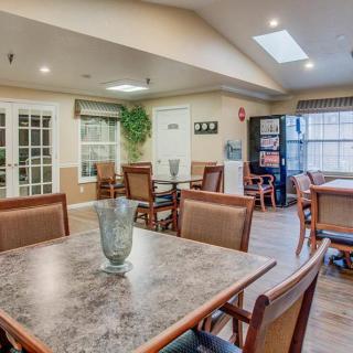 A well-lit dining area with tables and chairs arranged neatly.