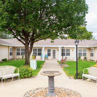 A serene courtyard with a central fountain, surrounded by benches and greenery.