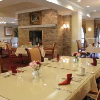 An elegant restaurant dining area featuring neatly set tables and a cozy fireplace.