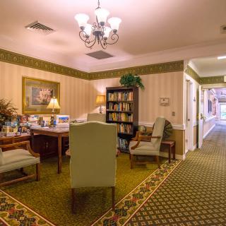 A cozy lounge room with elegant furniture and a well-stocked bookshelf.
