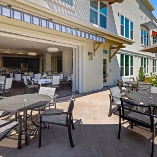 Outdoor seating area at a restaurant with tables and chairs on a sunny day.