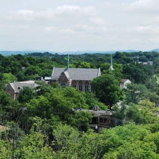 A church surrounded by lush green trees in a scenic landscape.