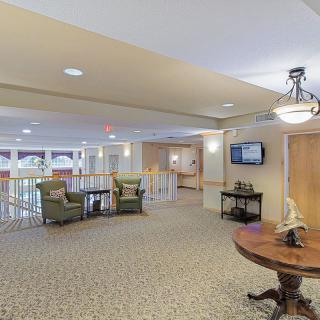 A spacious lobby with comfortable seating, elegant lighting, and a large carpeted area.