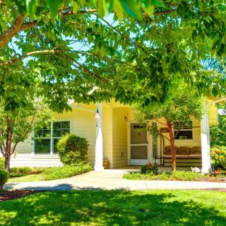 A charming suburban house surrounded by lush greenery and trees.