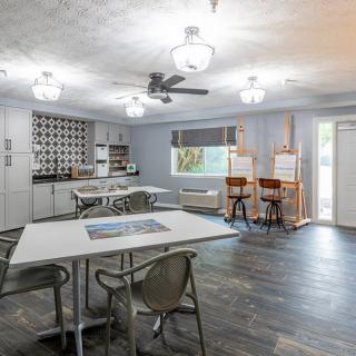 A modern kitchen and dining area with art easels and stylish lighting.
