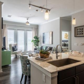 A modern open-concept kitchen and living room with elegant decor and soft lighting.