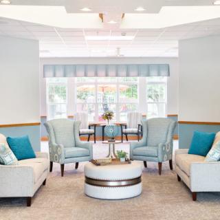 A modern living room with light-colored sofas and chairs, featuring a cozy and contemporary design.