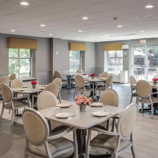 A bright and clean dining room with neatly arranged tables and chairs.