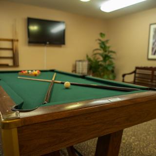 A cozy game room featuring a pool table and television for entertainment.