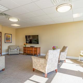A spacious, well-lit living room with comfortable seating and a television.
