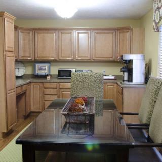 A modern kitchen with wooden cabinets and a dining table.