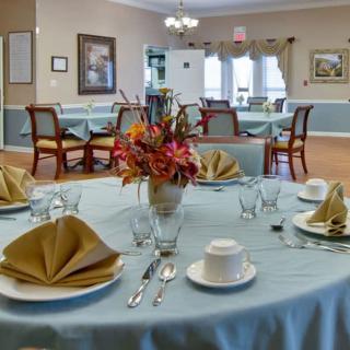 A beautifully set dining table with a floral centerpiece in an elegant restaurant.