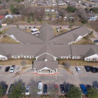 Aerial view of a residential community center with an expansive parking lot.