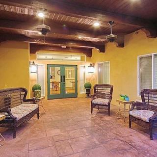 A cozy outdoor patio with wicker seating and ceiling fans.
