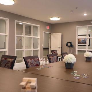 A well-arranged conference room with a long table, chairs, and floral decorations.