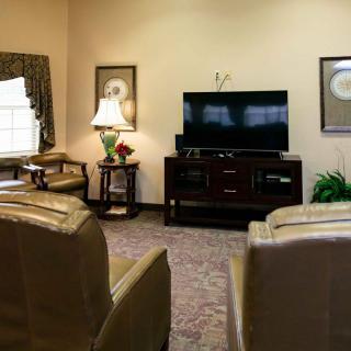 A cozy living room with comfortable seating and a TV entertainment center.