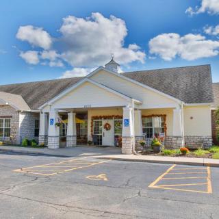 A building with a welcoming entrance and a spacious parking lot under a cloudy sky.