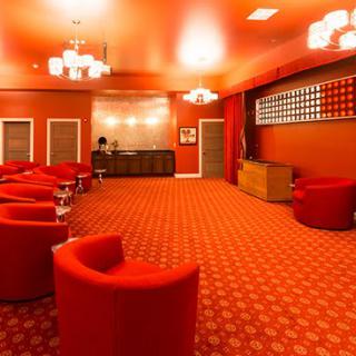 A stylish red lounge featuring modern seating and elegant chandeliers.