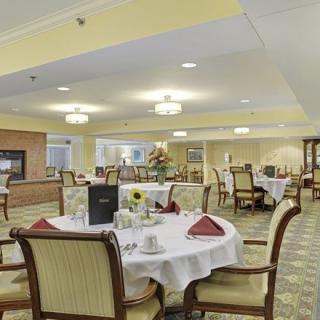An elegant dining room with neatly set tables and comfortable chairs, ready for guests.