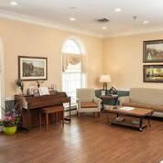 A cozy living room featuring a piano, comfortable seating, and tasteful decor.
