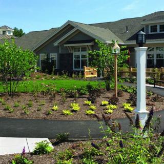 A well-maintained garden with a pathway leading to a house.