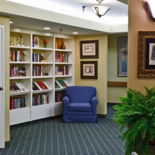 A cozy reading corner with a bookshelf and armchair.