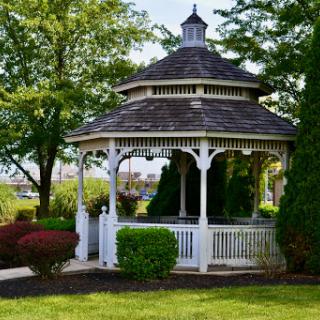 A charming gazebo surrounded by lush greenery, perfect for relaxation and enjoying nature.