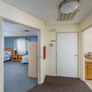 A hallway leading to a bedroom and bathroom, typical of a care facility setting.