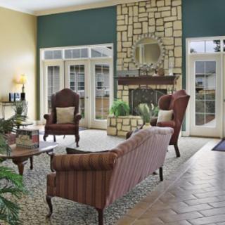 A cozy living room with classic furniture and a stone fireplace.