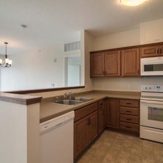 A modern kitchen with wooden cabinets and white appliances.
