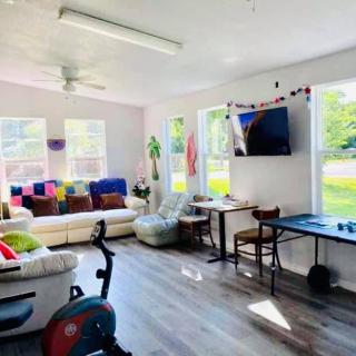 A bright and cozy living room with a sofa, exercise bike, and flat-screen TV.