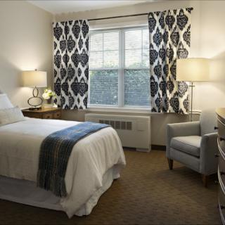 A cozy and modern bedroom featuring stylish curtains, soft lighting, and comfortable furnishings.