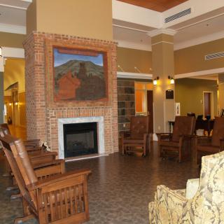 A cozy lobby featuring a fireplace, seating area, and artwork above the mantel.