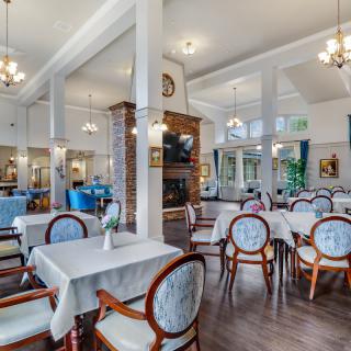 A spacious and elegantly decorated restaurant dining area with neatly arranged tables and chairs.