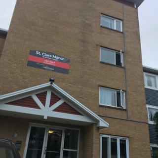A multi-story apartment building featuring a prominent sign.