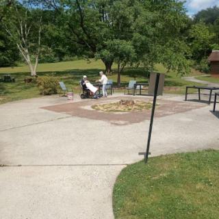 A serene park setting featuring a fire pit and seating area, perfect for gatherings.