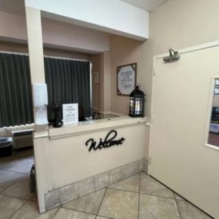 A hotel reception area with a welcome sign and tiled flooring.