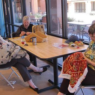 A group of women enjoy a knitting session indoors.