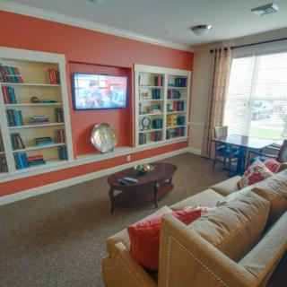 A cozy living room with a sofa, bookshelves, and a television.