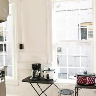 A bright kitchen space featuring a coffee maker and crockpot on a small table by the window.