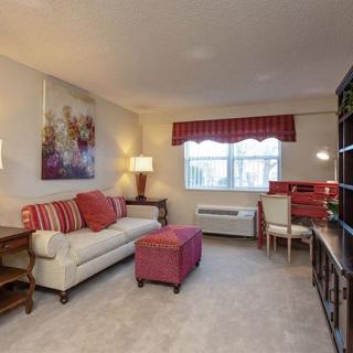 A cozy living room with a sofa, ottoman, and decorative accents in warm tones.