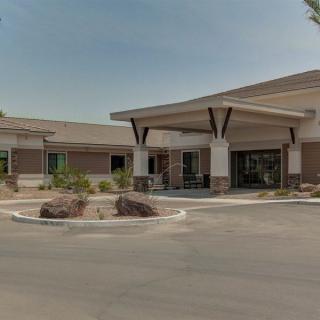 A modern commercial building with a parking lot and landscaped entrance.