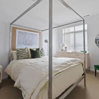 A modern bedroom with a four-poster bed and contemporary decor.