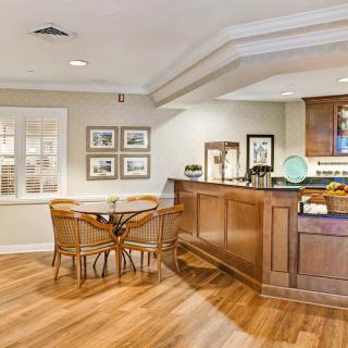 A cozy kitchen interior featuring a wooden bar counter and seating area.