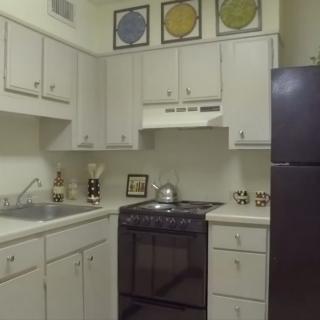 A small kitchen with white cabinets and modern appliances.