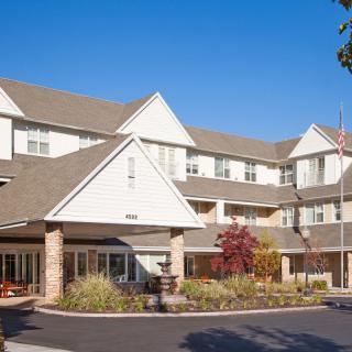 A three-story residential building with a welcoming entrance and landscaped surroundings.