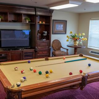 A cozy game room featuring a billiards table and a large television.